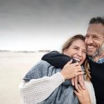 Dating after 40 symbolized by a man who strolls happily with his date at the beach
