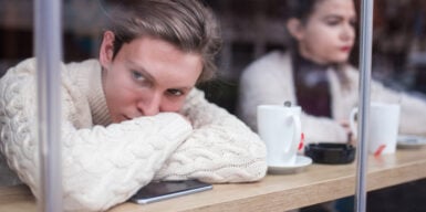 Woman looks thoughtfully out of the window and wonders why online dating doesn't work